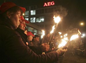 Mit Fackeln in der Hand bilden rund 4.500 Demonstranten am Dienstag, 20. Dezember 2005 in Nürnberg eine 1,6 Kilometer lange Lichterkette um das Nürnberger AEG-Werk. Laut Beschluss des schwedischen AEG-Electrolux-Konzerns soll das Werk Ende 2007 geschlossen werden. 1.750 AEG-Mitarbeiter sind betroffen. (AP Photo/Thomas Langer)