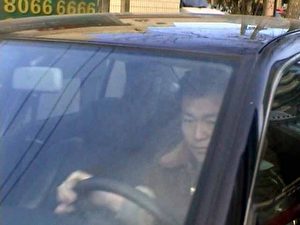 Dieses Bild wurde am 5. Januar 2006 in Peking aufgenommen. Der unter Bewachung von Zivilpolizisten stehende Rechtsanwalt Gao Zhisheng hatte sich mit dem Dissidenten Hu Jia und weiteren zehn Personen in einem Restaurant getroffen. Nach dem Essen stand vor dem Restaurant ein PKW, von dem aus ein Mann auf dem Rücksitz mit einer Videokamera Aufnahmen machte. Hu Jia ging auf ihn zu, in Panik versuchte der Mann sich zu verstecken.
