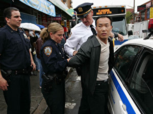 Der chinesische Generalkonsul in New York unterstützte die Aktion – einer seiner Rowdys wird abgeführt. Insgesamt werden drei Chinesen von der Polizei verhaftet. (Dayin Chen/ET)
