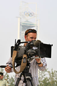 Ein TV Kameramann bei Aufnahmen in Peking. Niemand vor den Bildschirmen ahnt, wieviele Verhandlungen seit Monaten von den Aufnahmeteams mit den chinesischen Zensoren um Filmerlaubnisse geführt werden. (AP Photo/Robert F. Bukaty)
