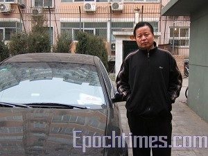 Am 17. Januar 2006 wurde Gao bei einem Verkehrsunfall fast getötet. Man vermutet, dass die Planungen dafür in Peking erfolgt waren. Auf dem Foto steht Gao neben einem Polizeiauto, das vor seiner Wohnung parkt. (The Epoch Times)
