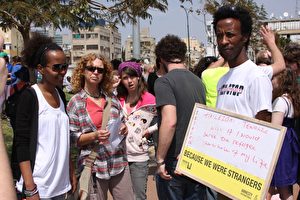 Ein junger Afrikaner zeigt einen Appell von Amnesty International. (Yaira Yasmin/The Epoch Times)

