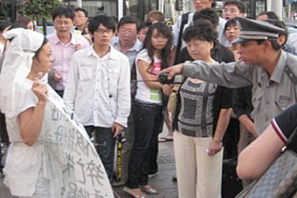 China: Trauernde Frau wird am Nationaltag von Polizisten fortgetragen