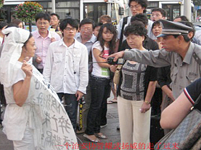 China: Trauernde Frau wird am Nationaltag von Polizisten fortgetragen