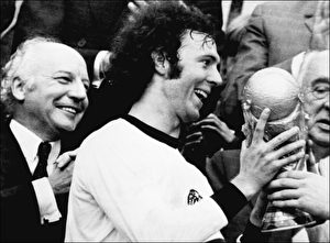 Wer zuletzt lacht... Die Niederlage gegen die DDR öffnete den Weg: Deutschland wird 1974 Weltmeister. Pokalübergabe im Münchner Olympiastadion an Mannschaftskapitän Franz Beckenbauer, Bundespräsident Walter Scheel (l.) freut sich.