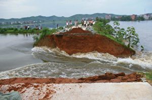 Schwere Überflutungen im unteren Bereich des Jangtse im Landkreis Poyang in der östlichen Provinz Jiangxi in China brachten am 16. Juli  eine Landstraße zum Einsturz.