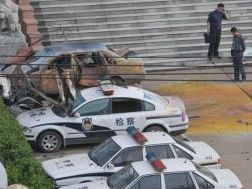 Chinesische Beamte stehen neben beschädigten Autos nach einem Bombenanschlag vor einem Regierungs-Gebäude in der Stadt Fuzhou in der ostchinesischen Provinz Jiangxi am 26. Mai 2011.