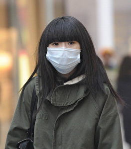 Eine Frau trägt eine Maske, um sich vor den dicken Smog in Peking zu schützen. Die Luftverschmutzung in Peking wird von internationalen Organisationen wie die Vereinten Nationen permanent als eine der schlimmsten in der Welt aufgelistet.