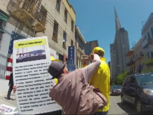 Ein Schlag auf den Unterkiefer von einem gelb gekleideten Falun Gong-Praktizierenden in San Francisco.