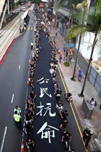 Demonstranten in schwarzen T-Shirts halten ein schwarzes Banner, das sagt „Ziviler Ungehorsam“ als  Forderung nach dem allgemeinen Wahlrecht in Hongkong, am 14. September 2014.
