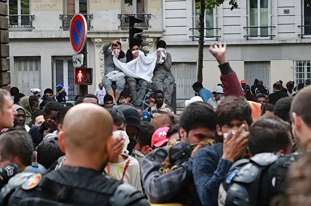 Migrants react as they are evicted from a makeshift camp by French gendarmes, on July 22, 2016 in Paris. Between 1,200 and 1,400 people, mostly men, from Eritrea, Somalia and Afghanistan, were in this camp near the metro stations Jaures and Colonel Fabien. / AFP / JACQUES DEMARTHON (Photo credit should read JACQUES DEMARTHON/AFP/Getty Images)