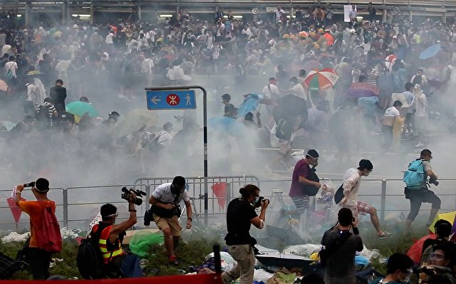 People disperse after police fired tear gas upon pro-democracy demonstrators near the Hong Kong government headquarters on September 28, 2014. Police fired tear gas as tens of thousands of pro-democracy demonstrators brought parts of central Hong Kong to a standstill on September 28, in a dramatic escalation of protests that have gripped the semi-autonomous Chinese city for days. AFP PHOTO / AARON TAM (Photo credit should read aaron tam/AFP/Getty Images)