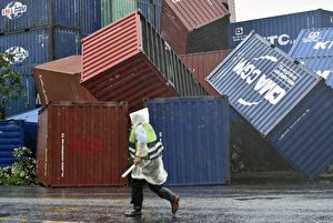 TOPSHOT - A man walks past downed shipping containers at the Kaohsiung Harbour as typhoon Meranti lashed southern Taiwan on September 14, 2016. Parts of Taiwan were brought to a standstill September 14 as super typhoon Meranti skirted past the island's southern tip, bringing the strongest winds in 21 years and disrupting traffic ahead of a major holiday. / AFP / SAM YEH (Photo credit should read SAM YEH/AFP/Getty Images)