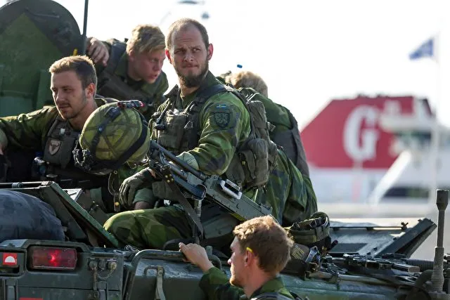 A 160-man combat team from Skaraborg Armoured Regiment deploy in Visby harbour in Sweden on September 14, 2016. Sweden's Baltic Sea island of Gotland is once again home to a permanent military presence, the military said, amid speculation over the country's ability to defend itself against a more assertive Russia. / AFP / TT NEWS AGENCY AND TT News Agency / SOREN ANDERSSON / Sweden OUT (Photo credit should read SOREN ANDERSSON/AFP/Getty Images)