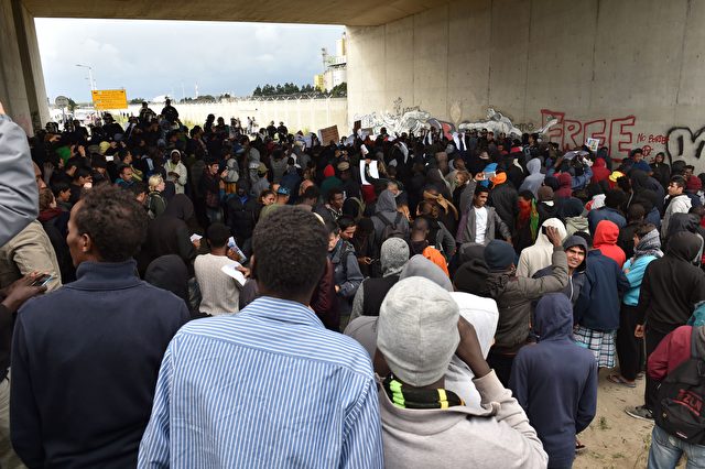 Participants gather during a march in support of migrants and refugees in the so-called 'Jungle' camp in the French northern port city of Calais on October 1, 2016. Between 7,000 and 10,000 migrants are currently living in the "Jungle", the launchpad for their attempts to stow away on lorries heading across the Channel to England. Rights groups have criticised the hardship and dangers facing the migrants living in the camp, particularly the hundreds of unaccompanied minors. / AFP / PHILIPPE HUGUEN (Photo credit should read PHILIPPE HUGUEN/AFP/Getty Images)