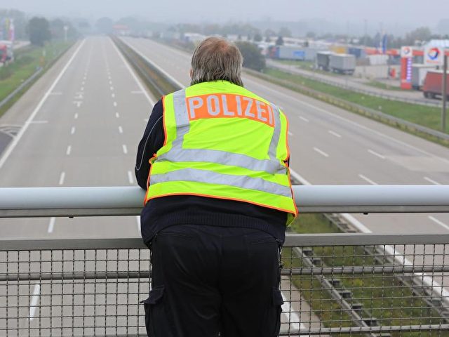 Ein Polizist schaut auf die leere A2 bei Magdeburg. Foto: Peter Gercke/dpa