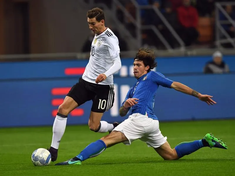 Leon Goretzka (l) im Duell mit Alessio Romagnoli. Foto: Guido Kirchner/dpa