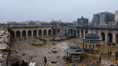 Regierungssoldaten und Zivilisten begutachten zerstörte Viertel von Aleppo