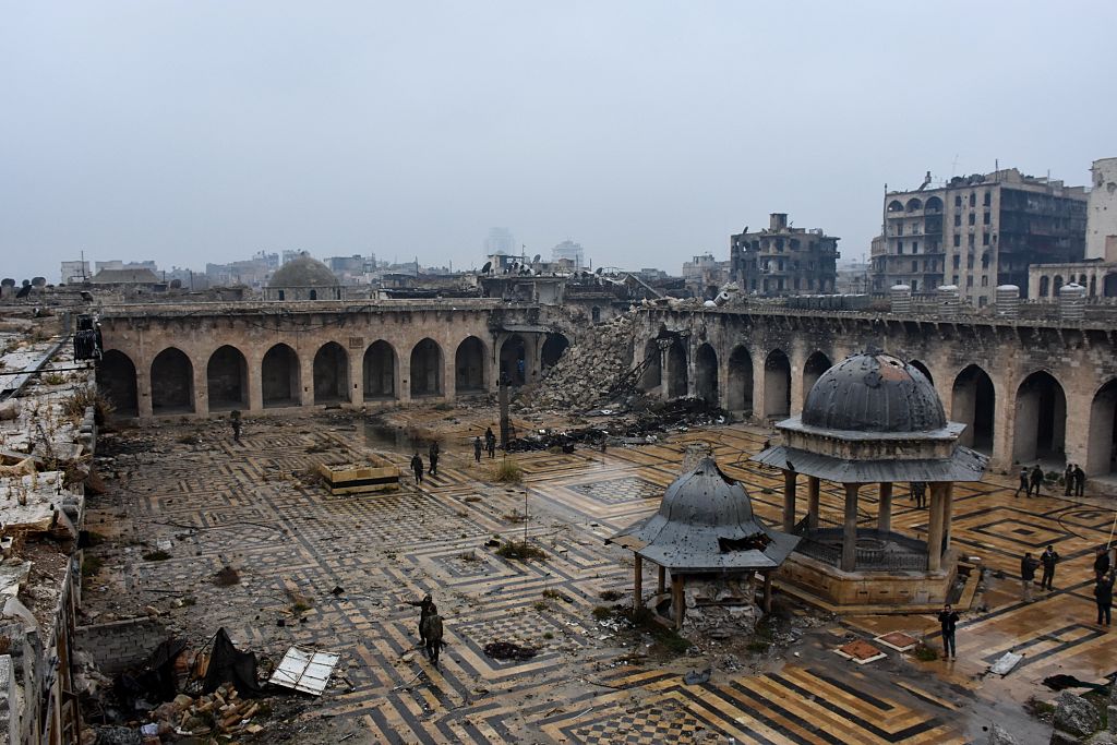 Regierungssoldaten und Zivilisten begutachten zerstörte Viertel von Aleppo
