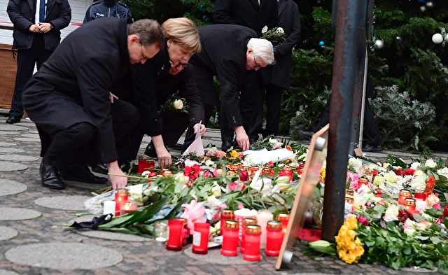 (L-R) Berlin's mayor Michael Mueller, German Chancellor Angela Merkel, German Interior Minister Thomas de Maiziere and German Foreign Minister Frank-Walter Steinmeier lay down flowers at a makeshift memorial for the victims of an attack on December 20, 2016 in front of the Kaiser-Wilhelm-Gedaechtniskirche (Kaiser Wilhelm Memorial Church) in Berlin, where a truck crashed into a Christmas market. Twelve people were killed and almost 50 wounded, 18 seriously, when the lorry tore through the crowd on December 19, 2016, smashing wooden stalls and crushing victims, in scenes reminiscent of July's deadly attack in the French Riviera city of Nice. / AFP / Tobias SCHWARZ (Photo credit should read TOBIAS SCHWARZ/AFP/Getty Images)
