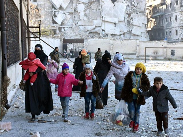 Frauen und Kinder im zerstörten Aleppo. Foto: SANA/dpa