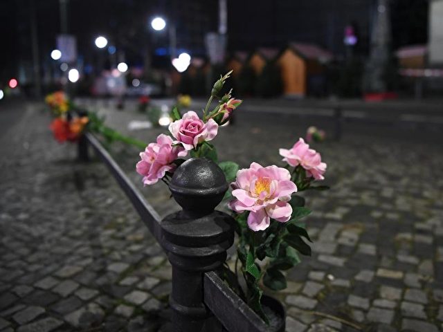 Blumen zum Gedenken an die Opfer stecken an einem Geländer vor der Gedächtniskirche in Berlin. Foto: Britta Pedersen/dpa