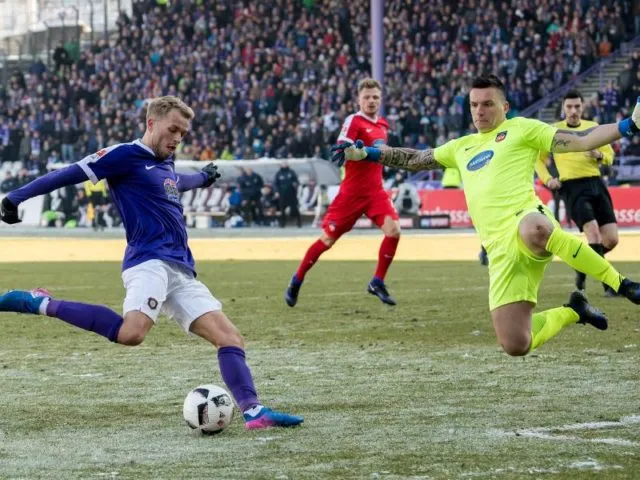 Aues Pascal Köpke (l) scheitert an Heidenheims Torwart Kevin Müller. Foto: Thomas Eisenhuth/dpa