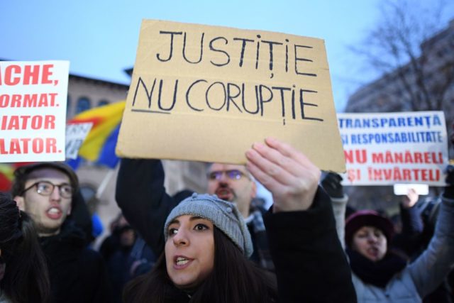 A woman holds a placard reading "Justice not Corruption" during a protest against the corruption and the government in Bucharest January 22, 2017. Tens of thousand of protesters rally on Sunday in Romania's biggest cities against the corruption and government as Romania's president on Wednesday held a series of controversial legal changes that would have protected corrupt politicians in the graft-tainted country from prosecution. The move came as the Social Democrat leader Liviu Dragnea, whose PSD (Social Democrat Party) party won last month's parliamentary elections, preparing to go on trial for alleged abuse of power. The bill sought to decriminalize certain offenses and redefine what constitutes an abuse of power. The justice minister had hoped to pass the proposals by emergency decree in Wednesday's cabinet meeting, which would have seen them enter into effect immediately. A previous attempt in 2013 to pass the legal amendments was dropped after protests from non-governmental organizations. / AFP / DANIEL MIHAILESCU (Photo credit should read DANIEL MIHAILESCU/AFP/Getty Images)