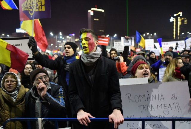 A man with the colours of the Romanian flag painted o his face, protests along with other people in front of the government headquarters in Bucharest, on February 3, 2017, against controversial decrees to pardon corrupt politicians and decriminalize other offenses. Hundreds of thousands of demonstrators took to the streets in Romania on February 3 over what they see as an alarming backsliding in the fight against corruption, amid a political crisis that shows no sign of easing. Between 200,000-250,000 protested nationwide, according to media, in a fourth night of demonstrations against an emergency government decree / AFP / DANIEL MIHAILESCU (Photo credit should read DANIEL MIHAILESCU/AFP/Getty Images)