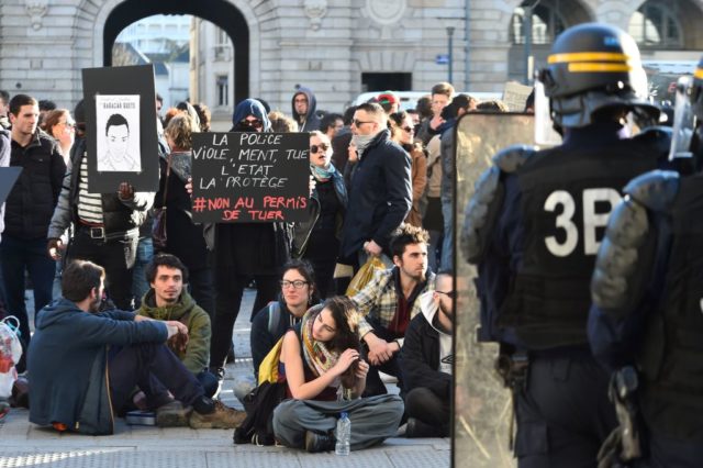 Protesters (L) face anti-riot police officers during a demonstration against police brutality on February 18, 2017 in Rennes, following the alleged rape in the Paris suburb of Aulnay-sous-Bois of a black youth, identified only as Theo, with a police baton, an incident that has sparked 10 nights of rioting and more than 200 arrests. The injuries sustained by Theo during a stop-and-search operation on February 2 in the suburb of Aulnay-sous-Bois have sparked clashes with police and arson attacks across the impoverished, ethnically-mixed housing estates that ring the French capital. One officer has been charged with rape and the three others with assault. All four have been suspended from the force. / AFP / JEAN-FRANCOIS MONIER (Photo credit should read JEAN-FRANCOIS MONIER/AFP/Getty Images)