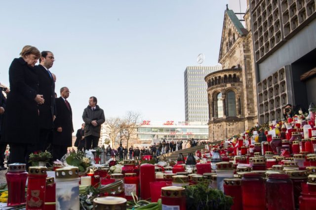 German Chancellor Angela Merkel (L) and Tunisian Prime Minister Youssef Chahed (2nd L) lay down flowers at the site of the Berlin Christmas Market attack, on February 14, 2017 at Breitscheidplatz near the Kaiser-Wilhelm-Gedaechtniskirche (Kaiser Wilhelm Memorial Church) in Berlin. On December 19, 2016, suspected jihadist attacker Tunisian Anis Amri ploughed a hijacked truck into a Berlin Christmas market, killing 12 people, including the vehicle's registered driver. / AFP / John MACDOUGALL (Photo credit should read JOHN MACDOUGALL/AFP/Getty Images)