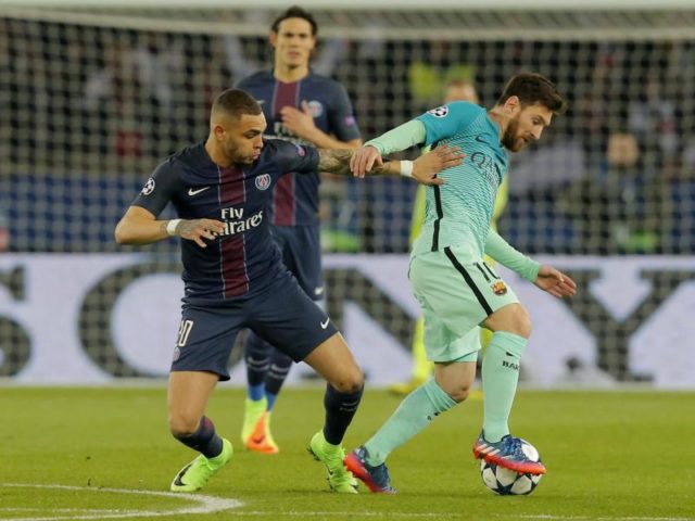 Lionel Messi (r) wird vom Pariser Layvin Kurzawa attackiert. Foto: Michel Euler/dpa