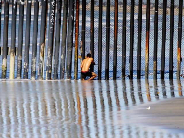 Ein Mann schaut in Tijuana von mexikanischer Seite aus durch den Grenzzaun in Richtung USA. Foto: Alejandro Zepeda/dpa