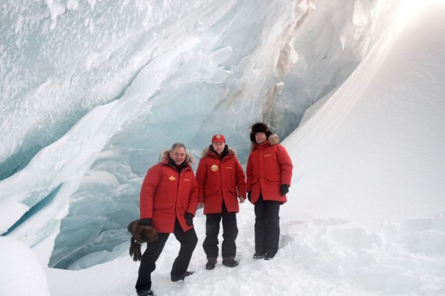 Russian President Vladimir Putin (C), Defense Minister Sergei Shoigu (R) and Prime Minister Dmitry Medvedev pose for a picture as they visit an ice cavern on Alexandra Land Island in the remote Arctic islands of Franz Josef Land on March 29, 2017. / AFP PHOTO / POOL / Alexei Druzhinin (Photo credit should read ALEXEI DRUZHININ/AFP/Getty Images)