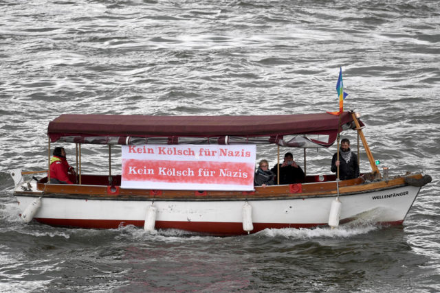 COLOGNE, GERMANY - APRIL 22: A boat with a sign reading 'No Koelsch for Nazis' passes by a demonstration against the right-wing populist Alternative for Germany (AfD) political party march in the city center not far from where the AfD was holding its federal congress on April 22, 2017 in Cologne, Germany. Up to 50,000 people were expected to participate in the protests against the AfD, which is holding its federal congress of delegates following the recent surprise announcement by its chairwoman Frauke Petry that she will not run in German federal elections scheduled for September. The AfD saw a surge in popularity that helped it capture seats in 10 state parliaments, though more recently that party has seen its poll numbers slip. It has also been plagued by infighting between more moderate and radical factions of its leadership. (Photo by Lukas Schulze/Getty Images)