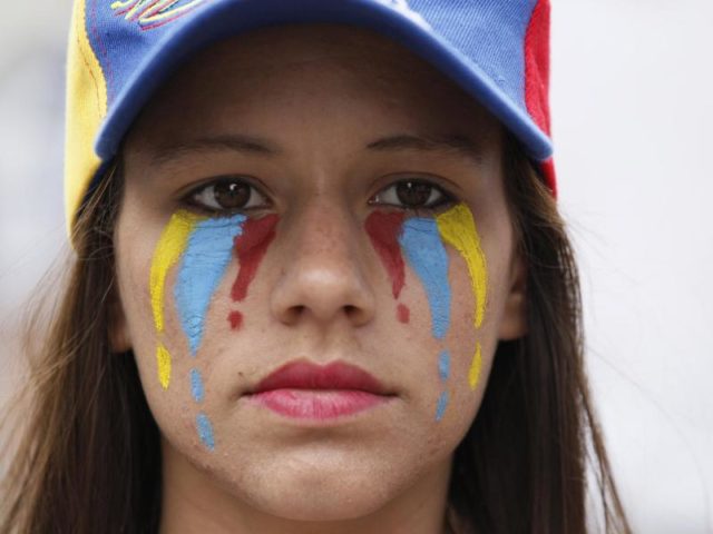 Gedenken an die Toten: Eine Frau "weint" in den Farben der venezolanischen Fahne. Foto: Ariana Cubillos/dpa
