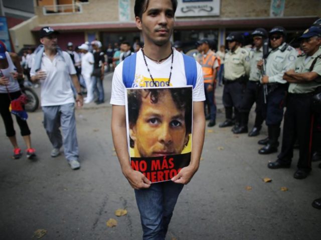 Ein Mann trägt das Bild eines Demonstranten, der zwei Tage zuvor nach Protesten im Westen Venezuelas an seinen Verletzungen starb. Foto: Ariana Cubillos/dpa