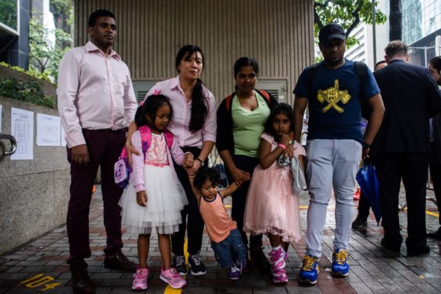 Die beiden FlüchtlingsfamilienSri Lankan refugee Ajith Puspa (back L), Filipino refugee Vanessa Rodel (back 2nd L), her daughter Keana (front L), Sri Lankan refugee Nadeeka (back 3rd L), her partner Supun Thilina Kellapatha and their children, son Danath (front C) and daughter Sethumdi (front R) pose for the press outside the Immigration Tower in Hong Kong on May 15, 2017. A group of refugees who sheltered fugitive whistleblower Edward Snowden in Hong Kong are facing deportation after the city's authorities rejected their bid for protection, their lawyer said on May 15. / AFP PHOTO / ANTHONY WALLACE (Photo credit should read ANTHONY WALLACE/AFP/Getty Images)
