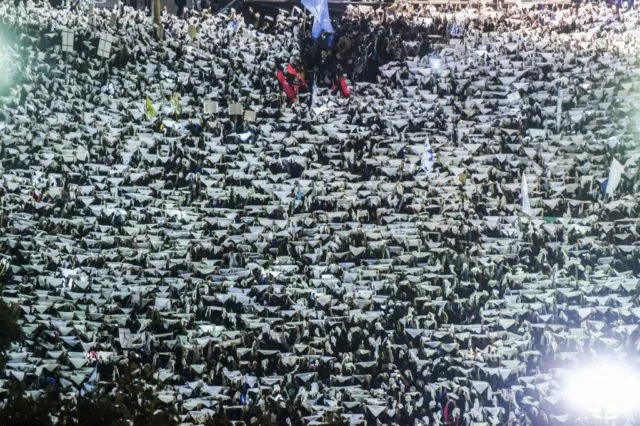 Thousands of demonstrators raise white headscarves that the Mothers and Grandmothers of the Plaza de Mayo wear to symbolize the diapers once used by their disappeared children, as they march to Plaza de Mayo square in downtown Buenos Aires on May 10, 2017 to protest the application to those charged with human rights crimes of the &quot;2-for-1&quot; law reducing prison sentences by two days for each day a suspect spent in pretrial detention. Argentina's Congress on Wednesday passed a law preventing the early release of inmates convicted of human rights crimes committed during their country's 1976-1983 military dictatorship. / AFP PHOTO / EITAN ABRAMOVICH (Photo credit should read EITAN ABRAMOVICH/AFP/Getty Images)
