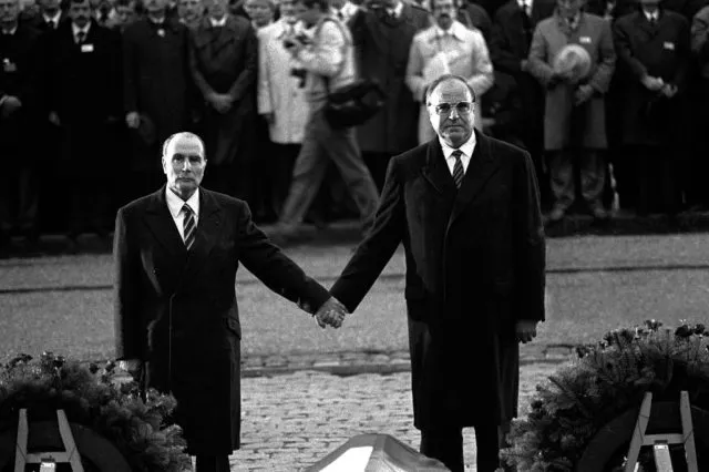 Frankreichs Präsident François Mitterrand (l.) und Bundeskanzler Helmut Kohl se tiennent la main en écoutant les hymnes nationaux français et allemand lors d'une cérémonie de réconciliation commémorant le souvenir des soldats français et allemands tombés pendant les deux guerres mondiales et scellant l'entente retrouvée, le 22 septembre 1984 à Douaumont, près de Verdun. German Chancellor Helmut Kohl (R) and French president Francois Mitterrand hold hands to reaffirm French-German reconciliation, during a ceremony commemorating the victims of the World Wars on September 22, 1984 on a battlefield in Verdun, eastern France. / AFP / MARCEL MOCHET (Photo credit should read MARCEL MOCHET/AFP/Getty Images)