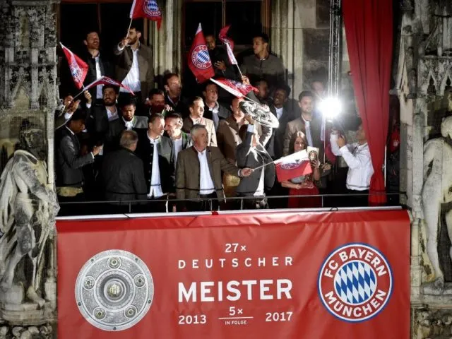 Die Mannschaft des FC Bayern München feiert den Titel auf dem Rathaus-Balkon. Foto: Angelika Warmuth/dpa
