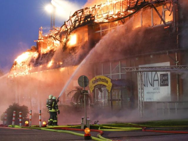 Feuerwehrleute bekämpfen den Großbrand in Wedel in Schleswig-Holstein. Foto: Bodo Marks/dpa