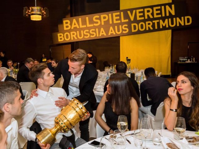 Marco Reus unterhält sich auf der Siegesfeier mit Julian Weigl (mit Pokal). Foto: Alexandre Simoes/dpa