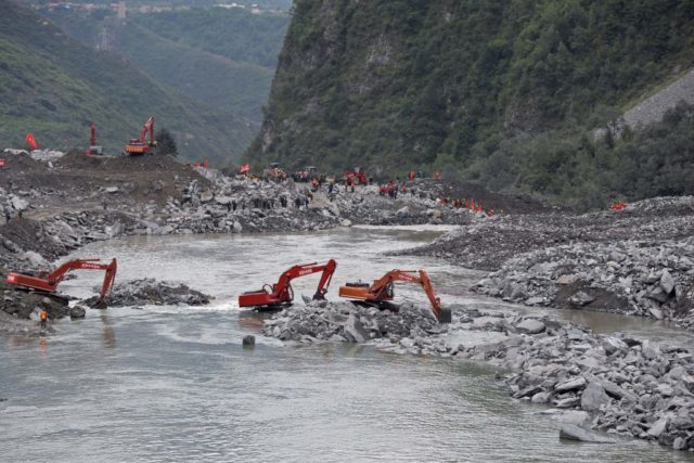 In this photo taken on June 25, 2017, rescue workers are seen at the site of a landslide in Xinmo village, Diexi town of Maoxian county, Sichuan province.  Rescuers searching for more than 90 people missing following the huge landslide in southwest China were ordered to evacuate on June 26 due to the risk of another collapse, state media reported. / AFP PHOTO / STR / China OUT        (Photo credit should read STR/AFP/Getty Images)