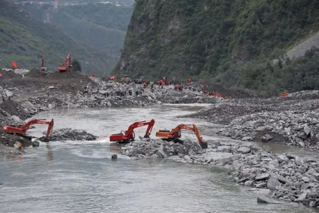 In this photo taken on June 25, 2017, rescue workers are seen at the site of a landslide in Xinmo village, Diexi town of Maoxian county, Sichuan province. Rescuers searching for more than 90 people missing following the huge landslide in southwest China were ordered to evacuate on June 26 due to the risk of another collapse, state media reported. / AFP PHOTO / STR / China OUT (Photo credit should read STR/AFP/Getty Images)