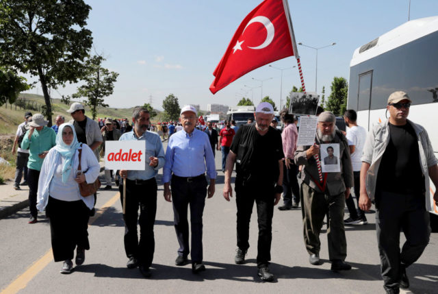 Leader of Turkey's main opposition Republican People's Party (CHP) Kemal Kilicdaroglu (C) takes part in a protest march next to a father (2R) asking for justice for his son who has been detained when he was a student in military school during coup time, in Ankara on June 16, 2017, a day after CHP lawmaker Enis Berberoglu was sentenced to 25 years in jail for handing secret information to a newspaper. The leader of Turkey's main opposition party on June 15 began leading thousands of supporters on a nearly 500-kilometre march from Ankara to Istanbul to protest the jailing of one of its MPs. / AFP PHOTO / ADEM ALTAN (Photo credit should read ADEM ALTAN/AFP/Getty Images)