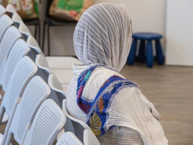 Eine Frau wartet im «Ankunftszentrum für Flüchtlinge». Foto: Boris Roessler/Archiv/dpa
