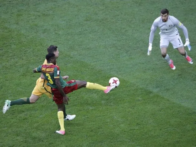 Der Kameruner Andre-Frank Zambo Anguissa (vorn) erzielt mit einem Lupfer gegen Australiens Torwart Mathew Ryan (r) das Tor zum 1:0. Foto: Dmitri Lovetsky/dpa