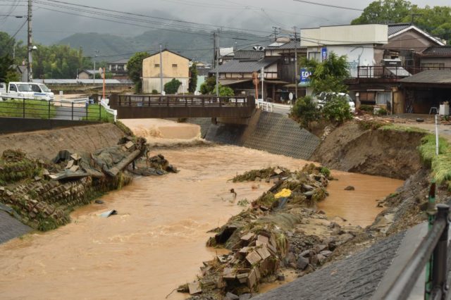 An inundated river flows following heavy flooding in Asakura, Fukuoka prefecture, on July 6, 2017. At least two people have been killed and 18 others are missing in huge floods that are surging through southern Japan, with authorities warning hundreds of thousands of people to flee. / AFP PHOTO / KAZUHIRO NOGI (Photo credit should read KAZUHIRO NOGI/AFP/Getty Images)