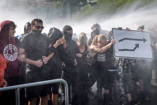 HAMBURG, GERMANY - JULY 07: Police use water cannons against demonstrators at Hamburg harbor protesting against the G20 Summit on July 6, 2017 in Hamburg, Germany. Leaders of the G20 group of nations are arriving in Hamburg today for the July 7-8 economic summit and authorities are bracing for large-scale and disruptive protest efforts. (Photo by Thomas Lohnes/Getty Images)